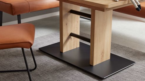 Auszugstisch interliving aus hellem Holz, Stühle in Lederoptik in dunklem orange