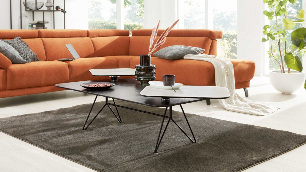 Wohnzimmertisch vor einem orangenen Sofa