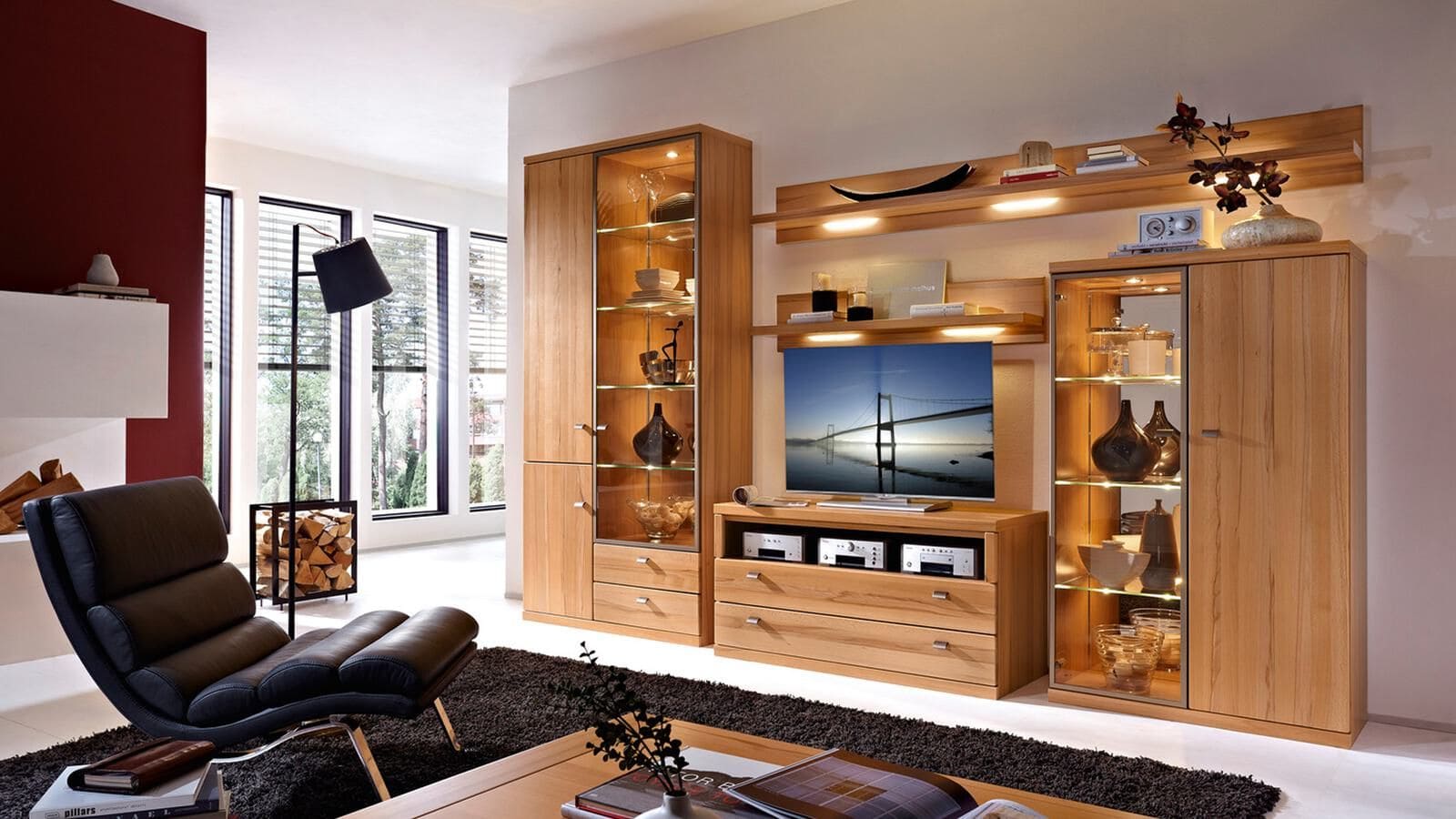 Wohnzimmer mit großer, holzfarbiger Wohnwand und vielen Glasvitrinen