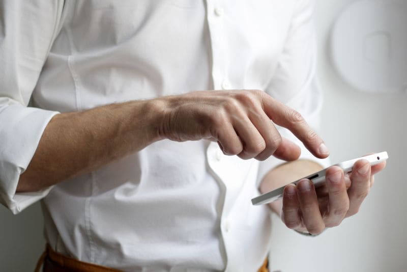Mann, der ein Handy in der Hand hält
