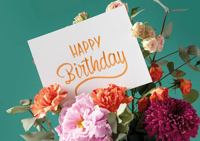 Blumen mit einer Happy Birthdaykarte, Türkise Hintegrund