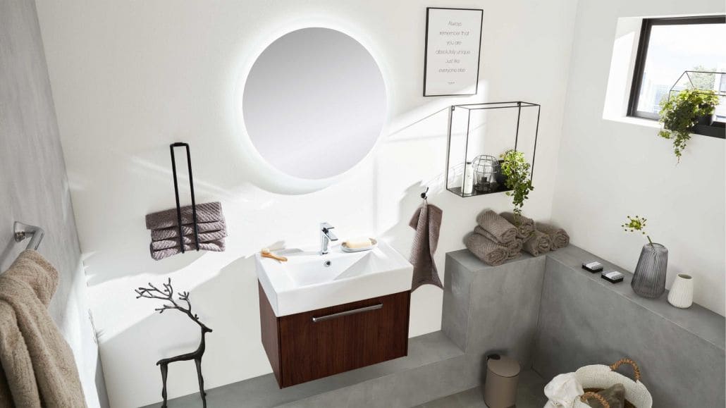 Kleines, modernes Badezimmer, mit einem runden Spiegel über dem dunkelbraun, weißem Waschbecken