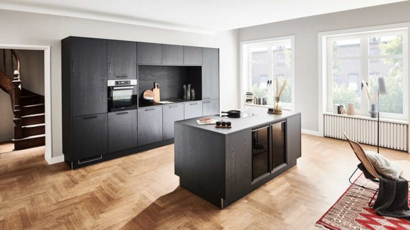 Moderne Küche in Schwarz in einer Küche mit Holzboden